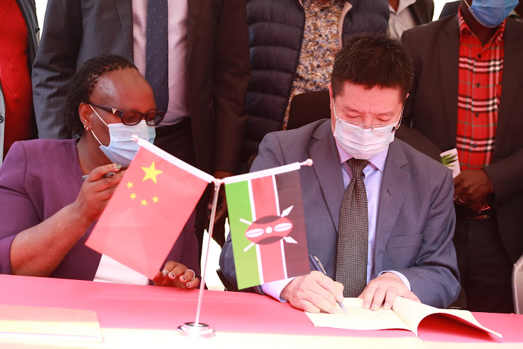 Williams Chin (left) signs aloe-vera MoU deal with Baringo County Government on Thursday.