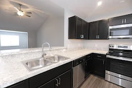 Stone inspired countertops and dark brown cabinets in kitchen