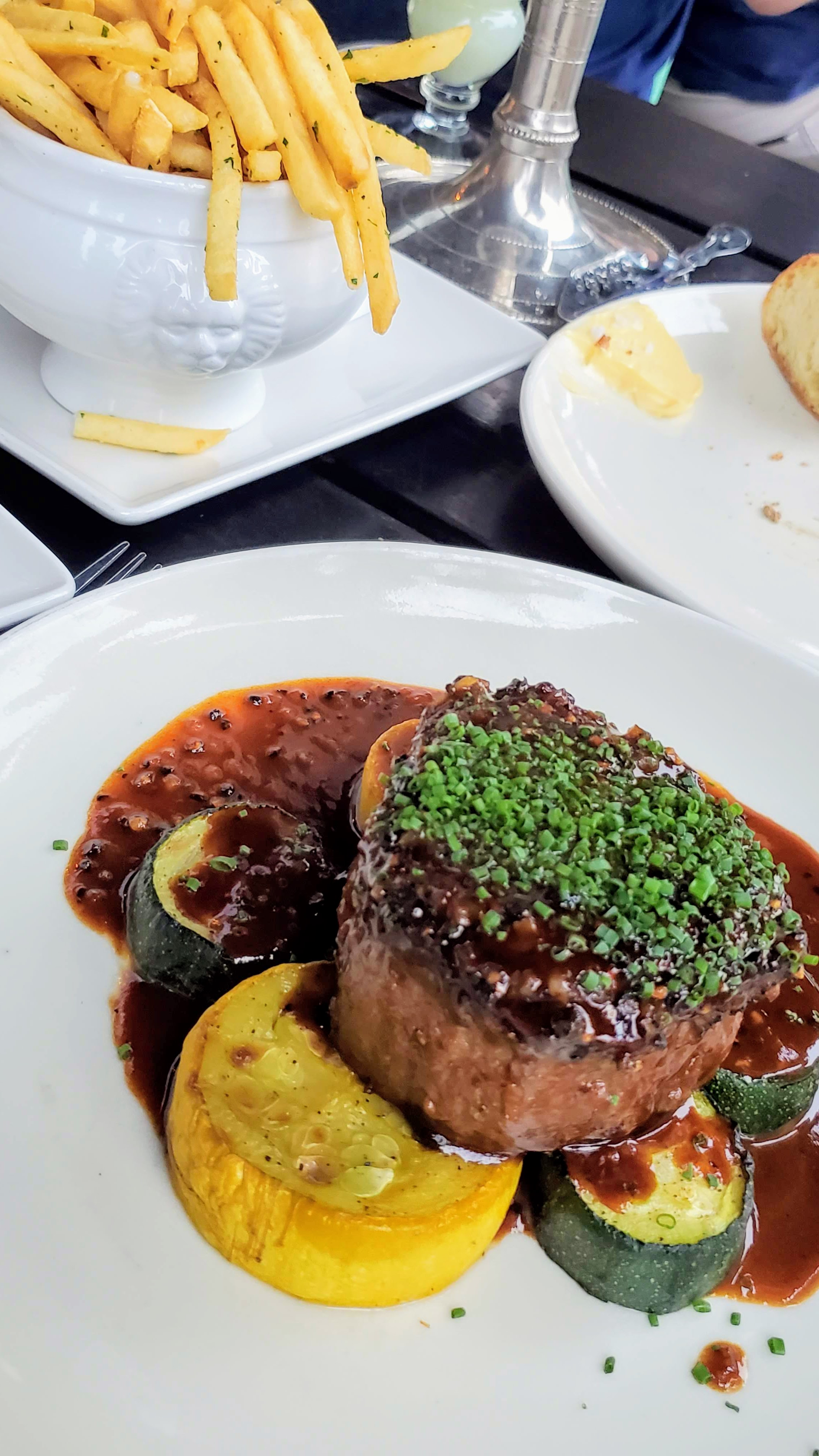 Recommendations at Bistro Agnes: Filet Mignon Au Poivre, a 6 oz black pepper-crusted beef tenderloin, madeira cream, roasted zucchini & summer squash shown