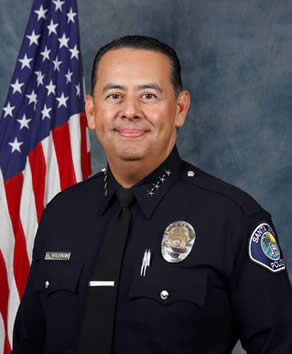 A picture of a man in black uniform next to the American flag