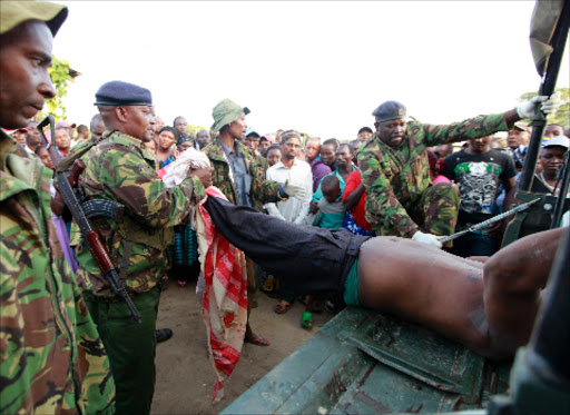 MASSACRE: Policemen yesterday remove the body of a man killed by gunmen in Mpeketoni, Lamu county, on Sunday evening. Photo/Reuters