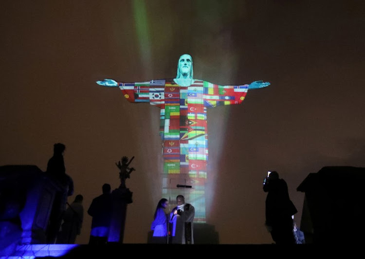 The statue of Christ the Redeemer is lit up in the flags of the countries affected by the coronavirus outbreak in Rio de Janeiro, Brazil, on March 18 2020.