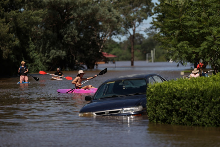 People using kayaks and paddle boards navigate a residential neighbourhood inundated with floodwaters as severe flooding affects the suburb of McGraths Hill in Sydney, Australia, March 24, 2021. REUTERS/Loren Elliott