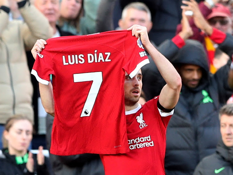 Liverpool's Diogo Jota holds up a shirt in support of Liverpool's Luis Diaz as he celebrates scoring their first goal.