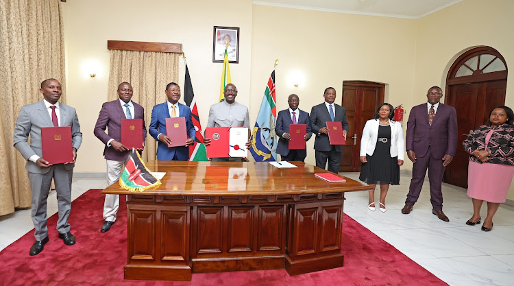 President William Ruto poses for a photo with senior state officials after signing in to law the Privatisation Bill at Kisumu State Lodge on October 9, 2023.