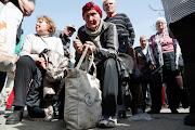 Ukrainians queue to register for social payments in the port city of Mariupol on April 26 2022. 