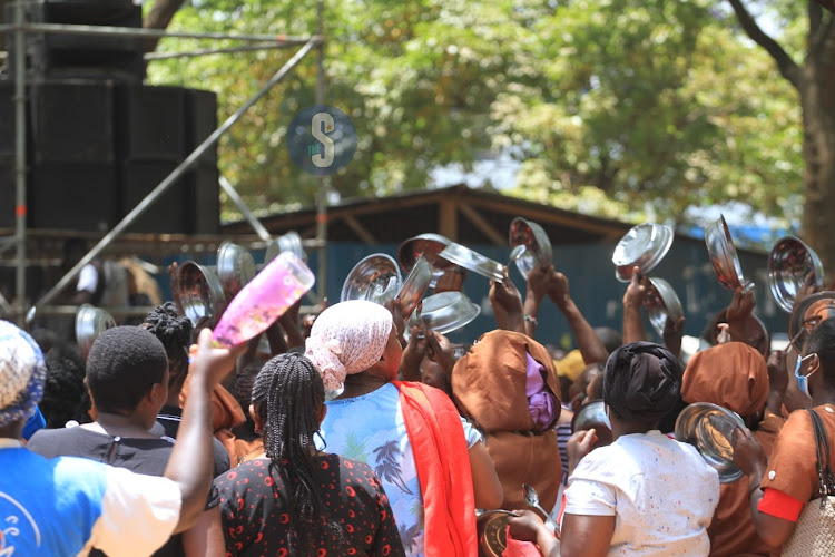 Kenyans wave empty plates in the air at Azimio prayer rally in Jevanjee on February 22.