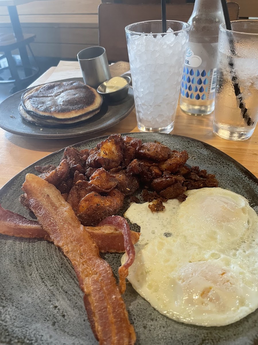 Bearcat Breakfast: crispy potatoes, two eggs over easy, and bacon. Two paleo blueberry pancakes in the back.