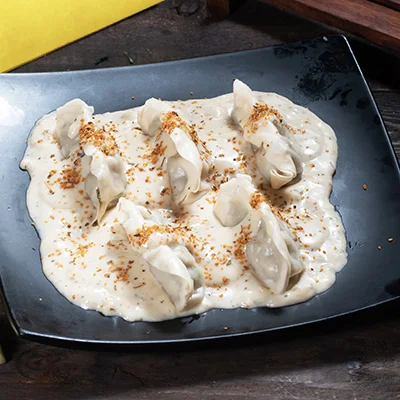 Veg Momo In Molten Cheesy Sauce