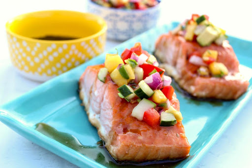 Two salmon pieces with mango salsa and maple glaze.