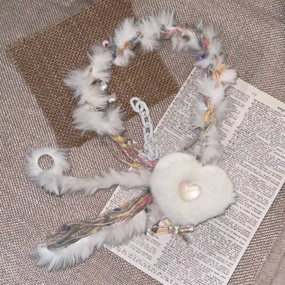 Collier ras de cou en peluche blanche avec cœur, un accessoire doux et élégant pour toutes les occasions. Confortable et parfait pour un look féminin.