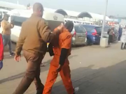 The inmate is apprehended by a correctional services official.