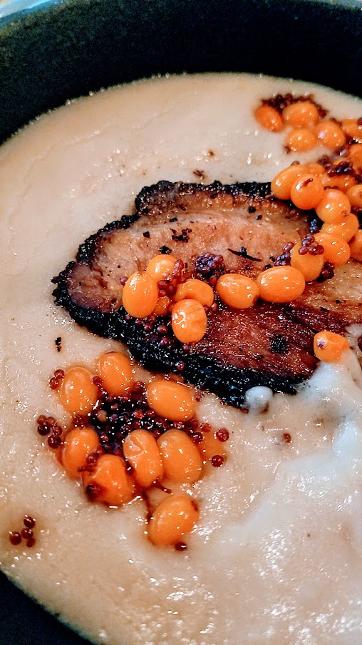 Belarusian pork belly machanka. pan gravy, blini and sea buckthorn berries