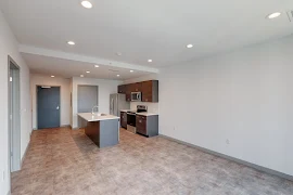 Living room with light walls and view of kitchen