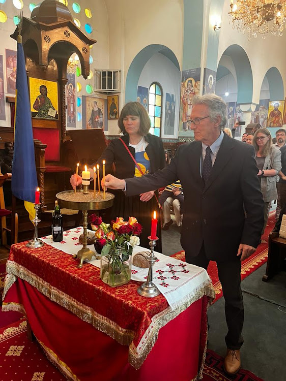 Guests place candles in a sandbox during the commemoration service for the victims of the Holodomor genocide at the Orthodox Patriarchal Cathedral of Sts. Cosmas and Damian, on Valley road, Nairobi on November 25, 2023.