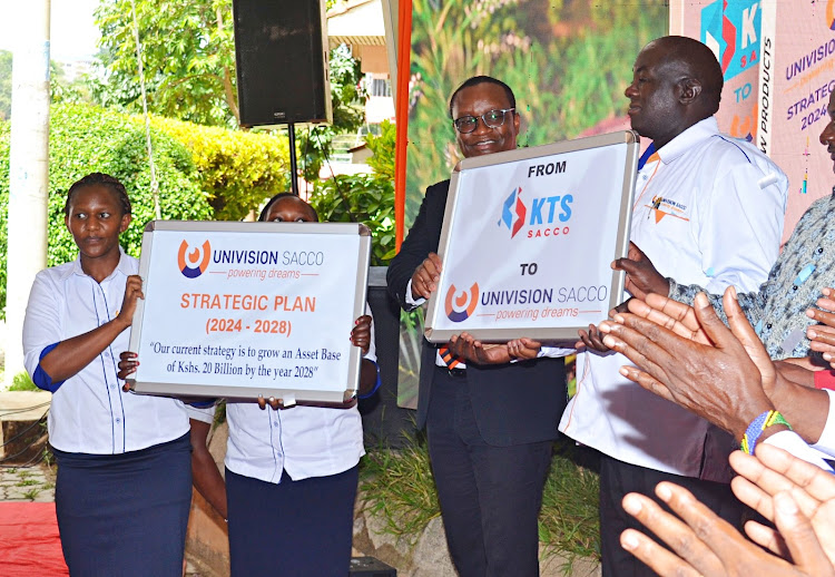 A director with the Co-op bank Vincent Marangu and the Univision Sacco Board chairman Rev. Augustus Munuve hold a banner indicating the transition from Kitui Teachers Sacco to Univision. Staffe members hold a banner on the strategic plan 2024-2028.