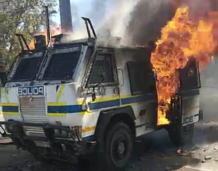 A police Nyala armoured personnel carrier in flames in Mthatha after a skirmish between protesting Walter Sisulu University students and police.