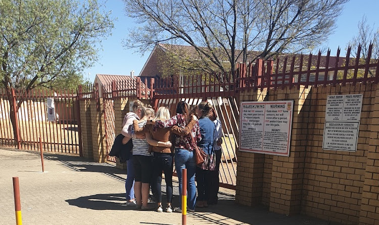 A group of mothers gathered at the school gate, praying for the safe return of the little girl.