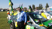 George Chauke with his car at the overflow park in Orlando, Soweto. The inside and outside of his car is decorated with ANC memorabilia and flags.