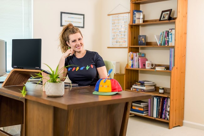 Mujer, Holly Slonaker, con cabello recogido y la cabeza recargada en la mano, con camiseta de lenguaje de señas de Google.