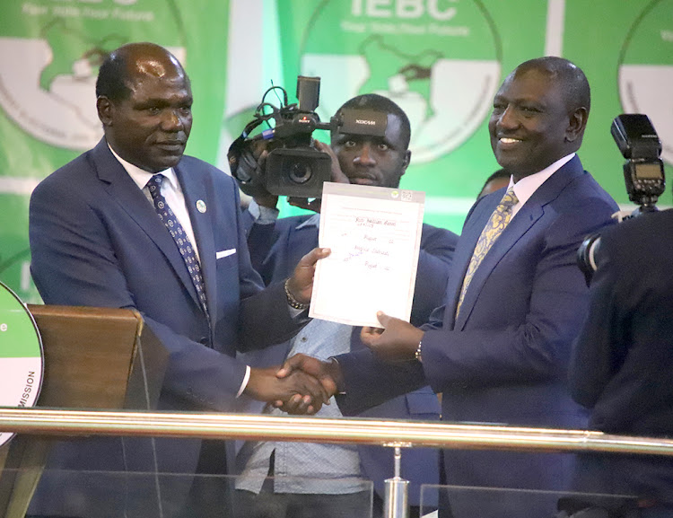 IEBC chairman Wafula Chebukati presents President-elect William Ruto his certificate at Bomas of Kenya on August 15