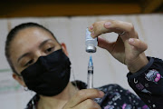 A Costa Rican health care worker prepares a dose of the AstraZeneca vaccine as part of a vaccination campaign against the coronavirus disease (Covid-19) targeting migrants regardless of their legal status, in San Jose, Costa Rica October 12, 2021. 