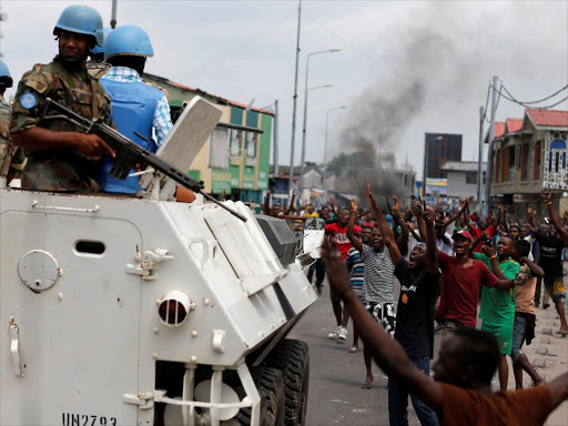 Residents chant slogans against Congolese President Joseph Kabila as peacekeepers serving in the United Nations Organization Stabilization Mission in the Democratic Republic of the Congo (MONUSCO) patrol during demonstrations in the streets of the Democratic Republic of Congo's capital Kinshasa, December 20, 2016. REUTERS/Thomas Mukoya