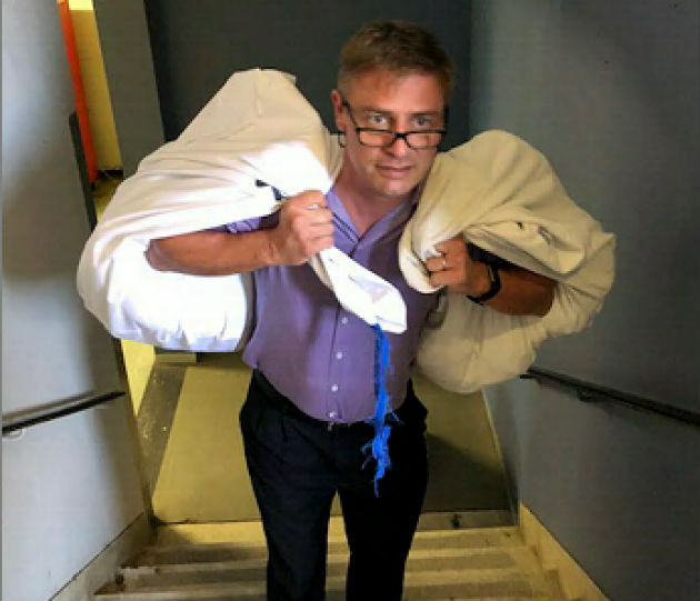 Provincial Hospital haematology department head Dr Neil Littleton takes clean linen up the stairs to his unit