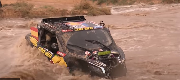 Dakar competitors struggle to cross a flooded river.