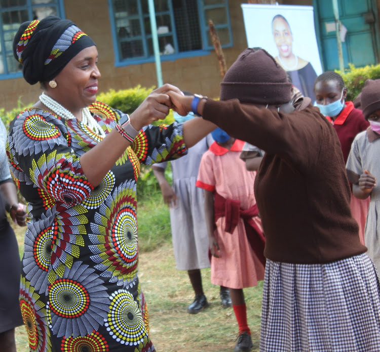 Nyeri Deputy Governor Caroline Karugu dances with a pupil at DEB Muslim Primary School in Nyeri town during celebrations to mark the World Menstrual Hygiene Day on Friday, May 28, 2021