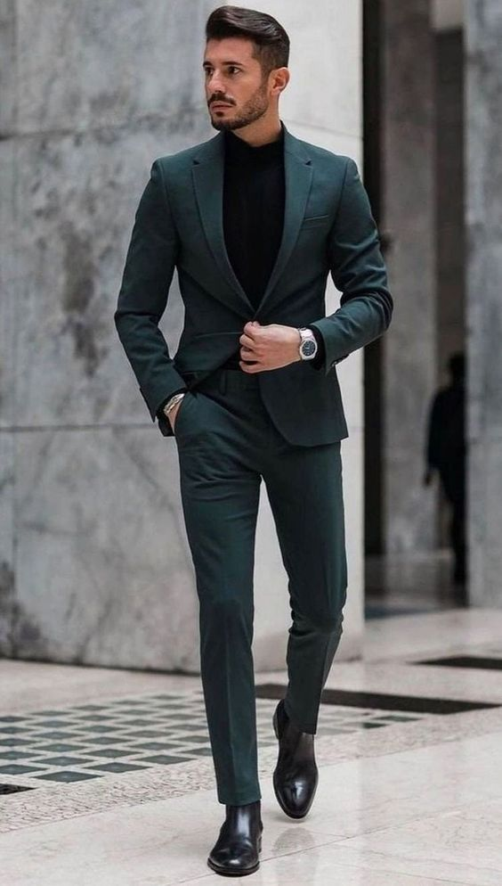 a man wearing a dark green suit prom outfits  for men