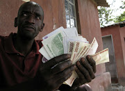 A man holding Zimbabwean dollars.