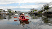 Visitors paddle around the residential marina on Knysna's Thesen Island, with its Cape Cod-style homes. 