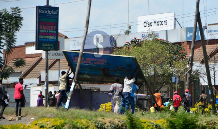 Vandals remove a signboard in Nakuru Town on July 12, 2023.