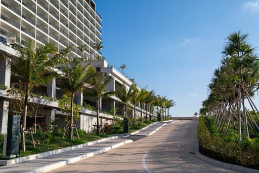 Modern building entrance with palm trees in this luxury property for sale in Onna ($634,898)