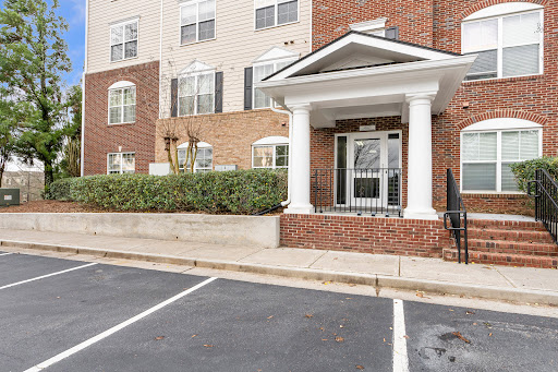 Brick building entrance with white columns in this luxury property for sale in Alpharetta ($365,750)