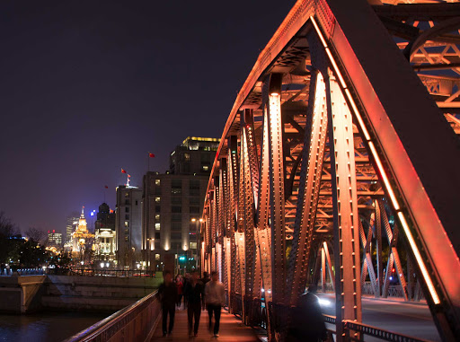 Young men cross the Waibaidu Bridge in the Lu Jia Zui District of Shanghai. China. 