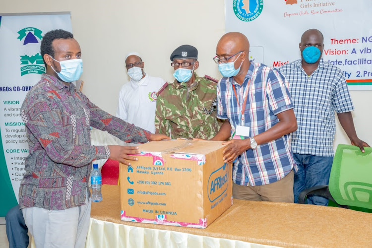 Sankuri assistant county commissioner George Koleshi (right) receives sanitary pads from Armed Noor representative of the Sisters Maternity Home during official opening of NGOs week in Sankuri.