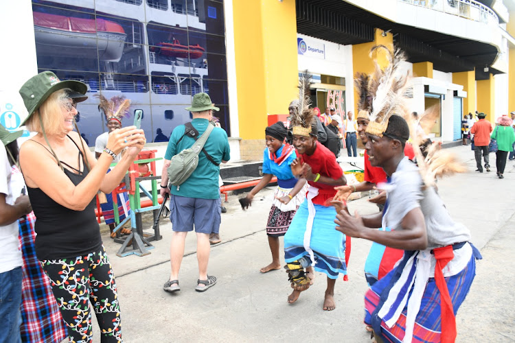 Tourists recording the traditional dancers after they arrived within the port of Mombasa while on board Mv.Nautical Majuro.