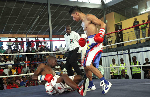 QUICK ENDING: Rey Loreto stands over challenger Nkosinathi Joyi who he beat on a stoppage in the first round of their title fight in Mdantsane yesterday Picture: MARK ANDREWS