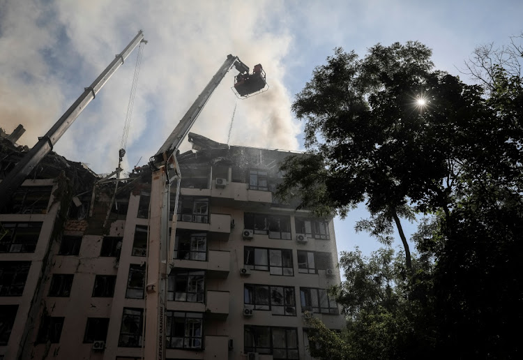 A rescue worker sprays water on an apartment building destroyed in a missile strike, amid Russia's invasion of Ukraine, in Kyiv, Ukraine June 26, 2022.