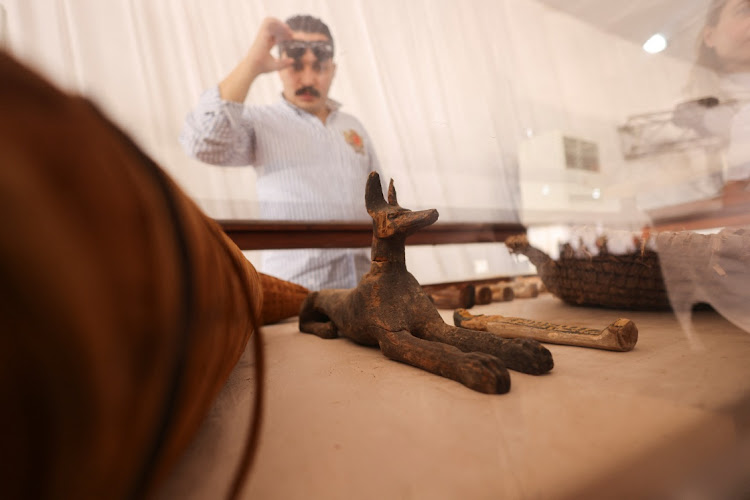 A man looks at recently unearthed ancient artefacts displayed after a conference to announce the newly discovered site where two embalming workshops for humans and animals along with two tombs and a collection of artefacts were found, near Egypt's Saqqara necropolis, in Giza, Egypt May 27, 2023.