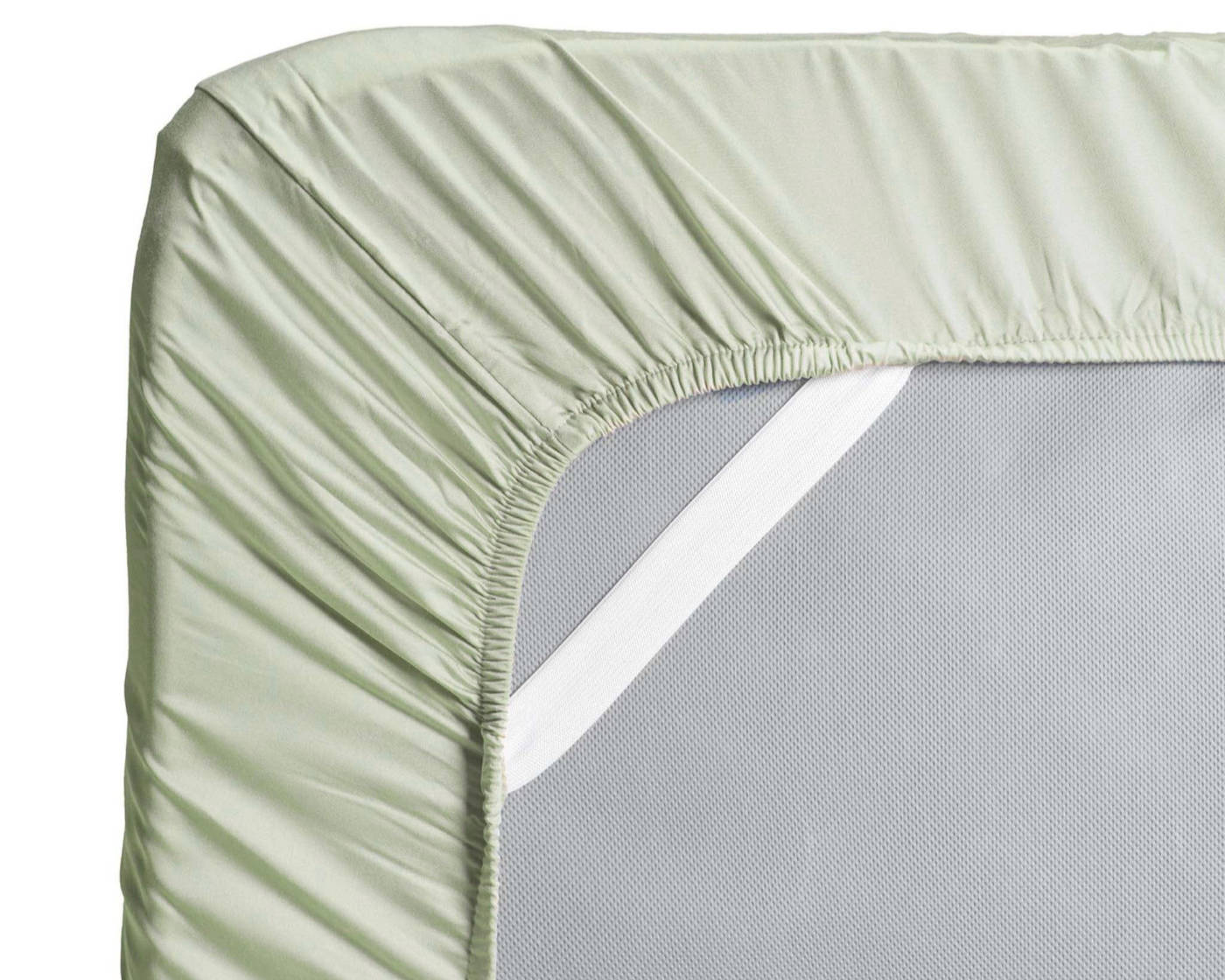 Hush fitted sheet in sage color with elastic band on mattress corner.