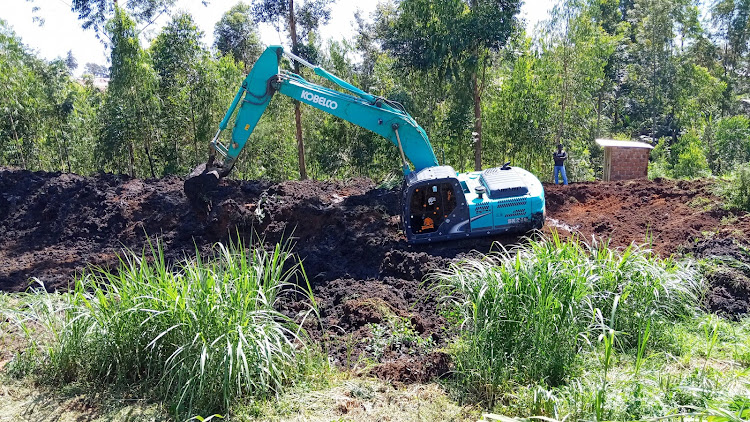 An excavator digs out one of the grabbed sewer lagoons in Kakamega yesterday