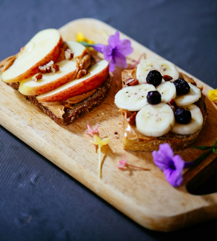 gute ernährung idee, zwei brotscheiben mit erdnussbutter, äpfel, bananen, blaubeeren, süße sandwiches