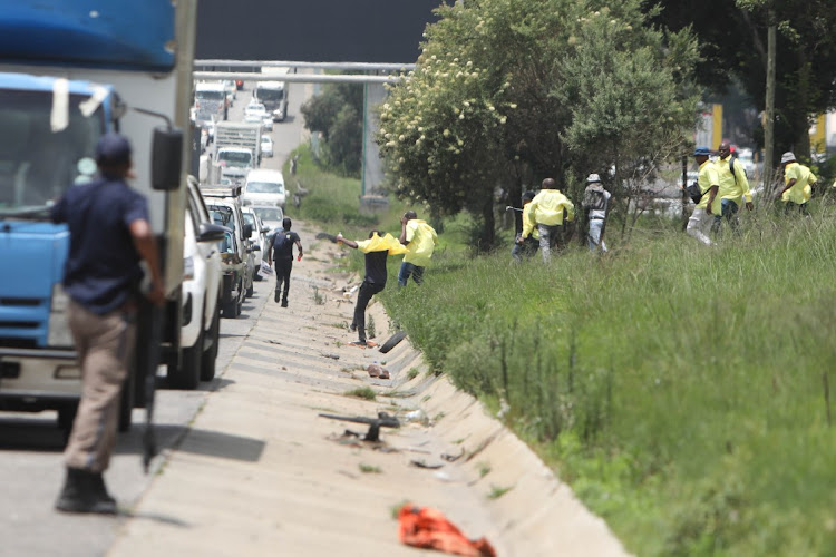 Striking Makro workers make their way onto the R24 highway on Friday near Makro Germiston, east of Johannesburg.