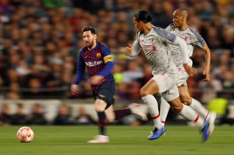 Barcelona's Lionel Messi dribbles past Liverpool's Fabinho and Virgil van Dijk