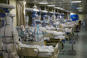 Medical workers in protective suits attend to Covid-19 patients at the intensive care unit (ICU) of a Wuhan hospital in February 2020.