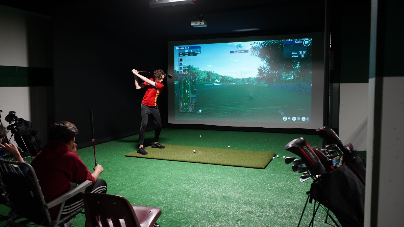 School student playing on golf simulator