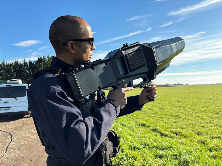 A French police officer poses with an anti-drone rifle during an exercise to test out anti-drone defence equipment at the military airbase of Villacoublay, near Paris on March 14, 2024.